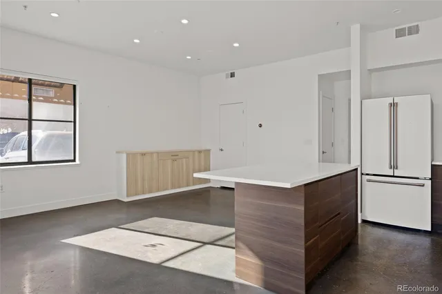 a kitchen with a refrigerator and white cabinets