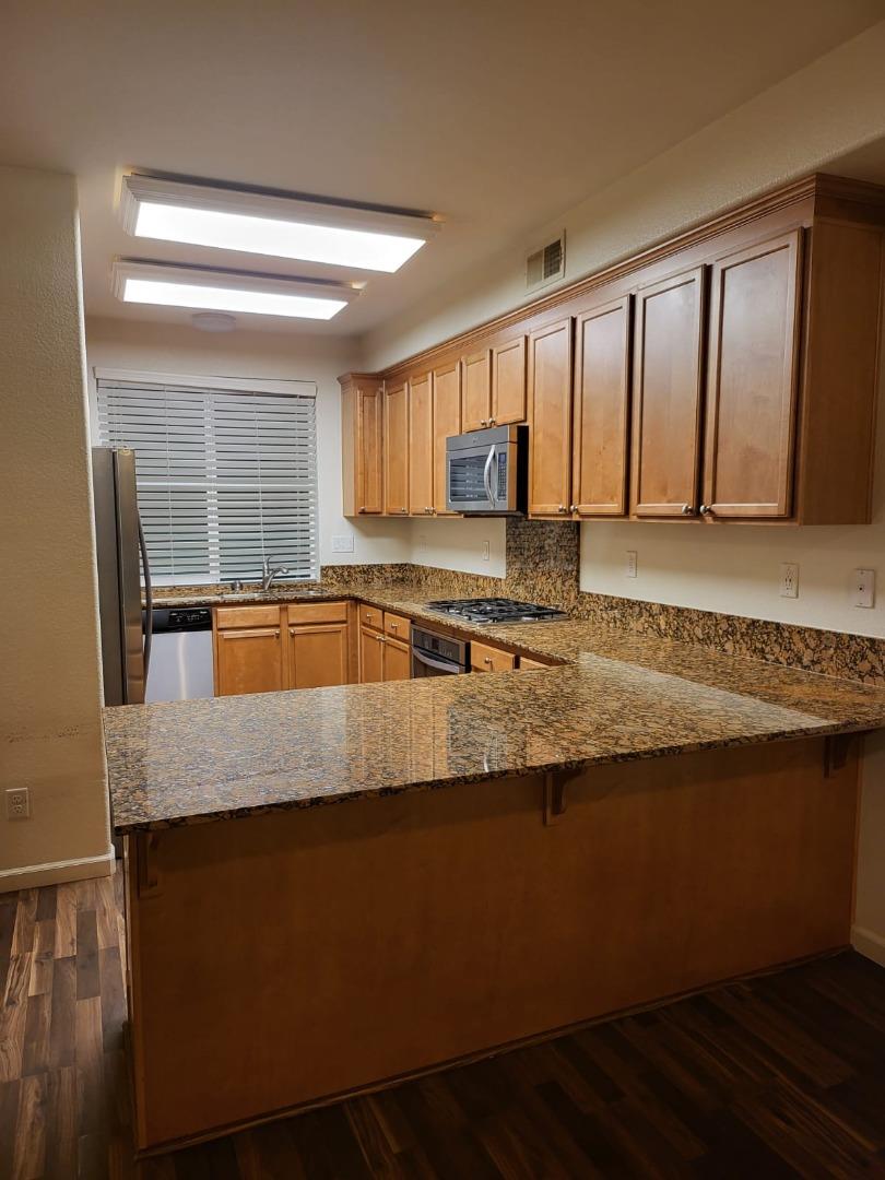 4708 Norris Canyon Road, Unit 203 San Ramon, CA 94583 - Photo 8 of 27 a kitchen with granite countertop a sink a stove and cabinets