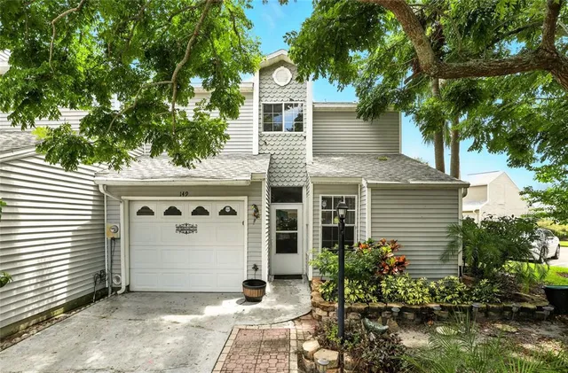a front view of a house with a tree