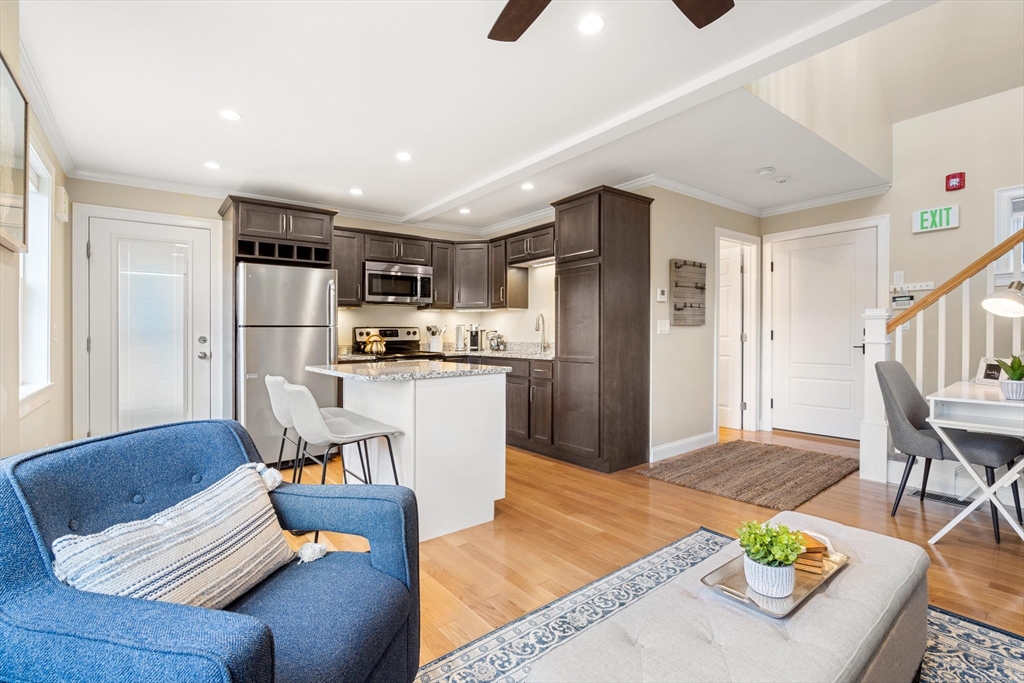48 Boston Road, Unit A Groton, MA 01450 - Photo 6 of 22 a living room with stainless steel appliances kitchen island granite countertop furniture and a wooden floor