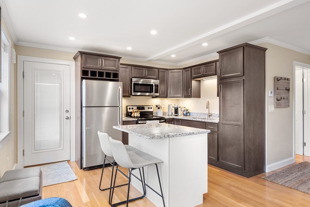 48 Boston Road, Unit A Groton, MA 01450 - Photo 9 of 22 a kitchen with stainless steel appliances granite countertop a refrigerator and a stove top oven
