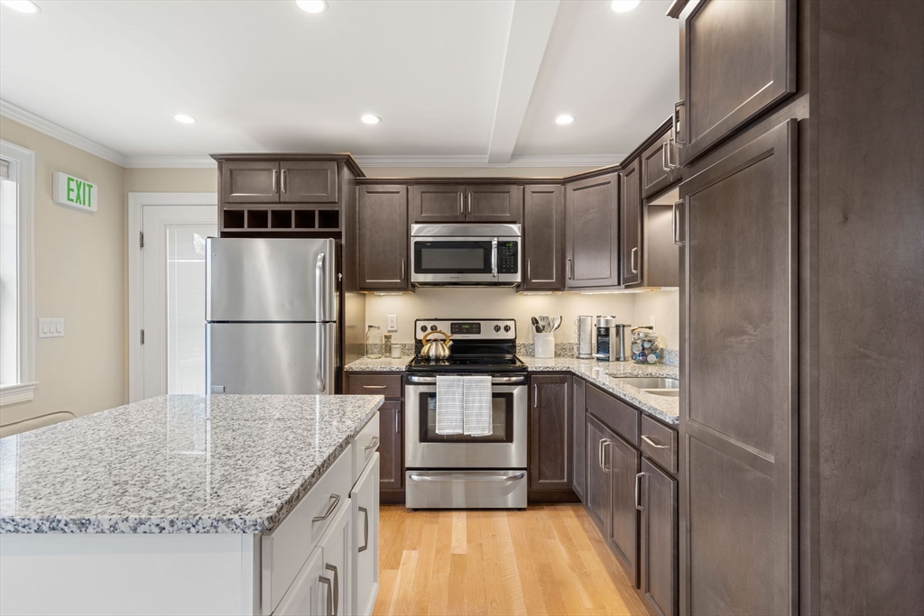 48 Boston Road, Unit A Groton, MA 01450 - Photo 10 of 22 a kitchen with stainless steel appliances granite countertop a refrigerator stove microwave and sink