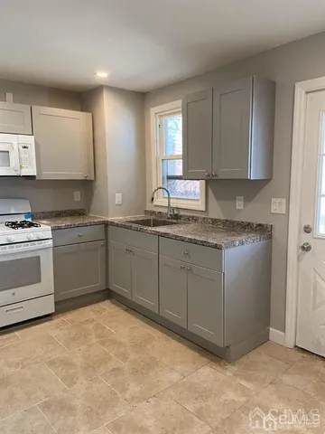 a kitchen with a stove a sink and a window