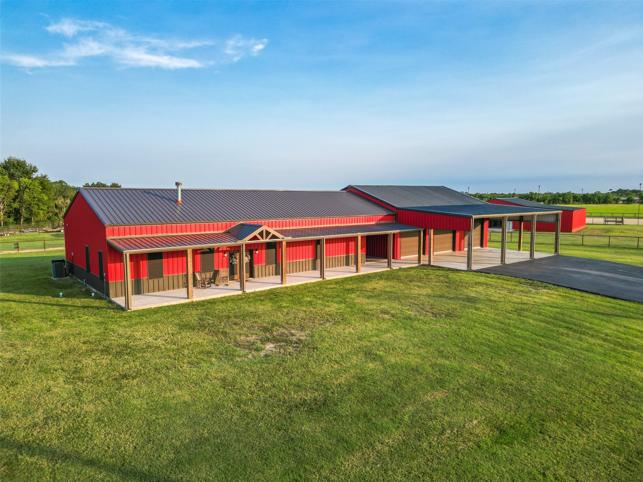 1402 Eagle Ferry Road Anahuac, TX 77514 - Photo 2 of 48 Custom 4-bedroom (or 3+office), 3-bath metal home with 10’ x 80’ covered front porch, attached 2,000 sq. ft. shop, and a paved asphalt driveway leading to the 25’ x 50’ covered parking with roll-up doors sized for a Class A motorhome or LQ horse trailer.