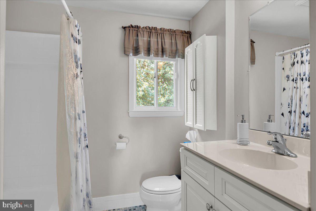 2575 West Colonial Drive Upper Chichester, PA 19061 - Photo 17 of 42 a bathroom with a sink a toilet a window and a mirror