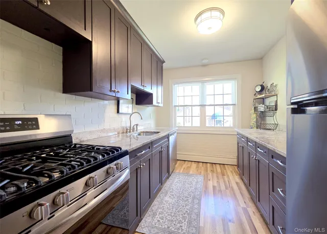 a kitchen with stainless steel appliances a sink dishwasher stove and oven