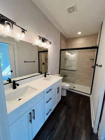 a bathroom with a double vanity sink and mirror with shower