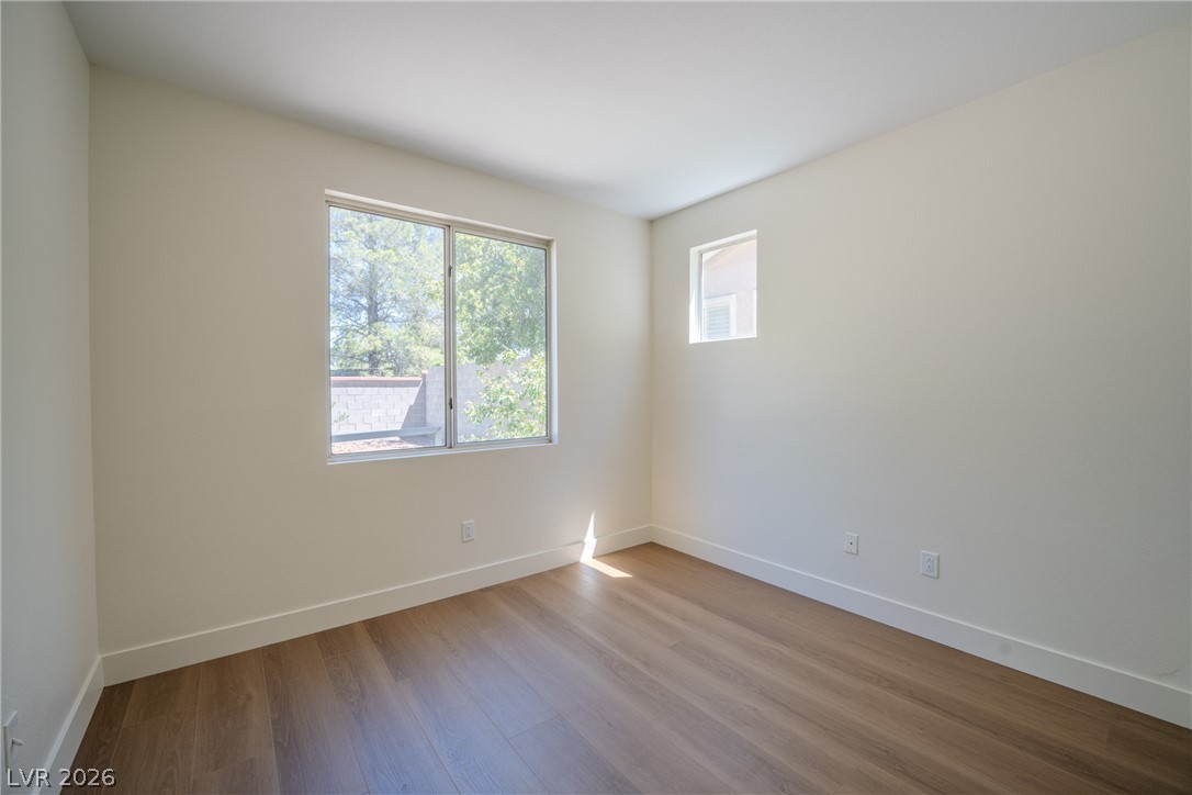 1832 Spring Summit Lane Las Vegas, NV 89134 - Photo 20 of 52 A well-lit bedroom features durable wood flooring and ample natural illumination through its windows.