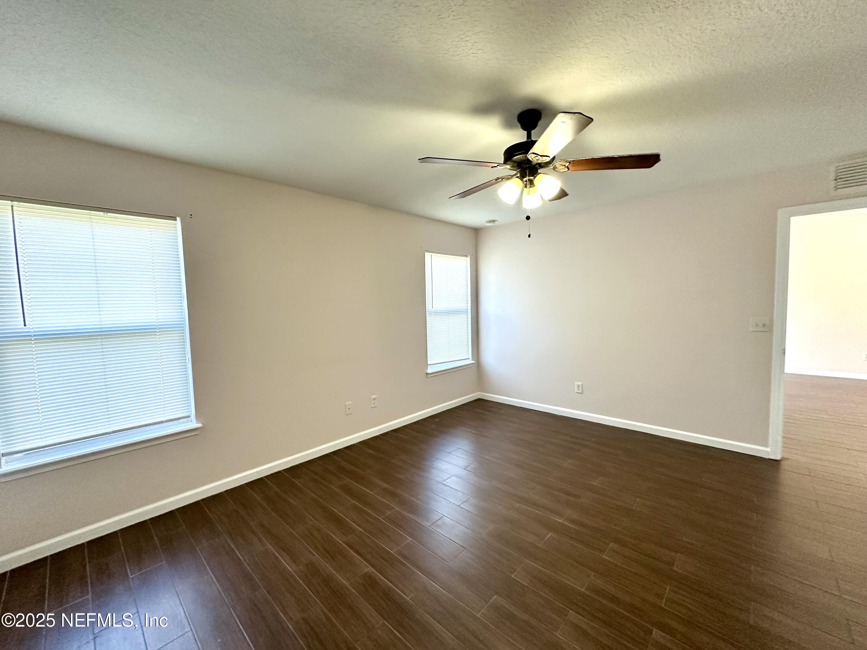 45575 Ingleham Circle Callahan, FL 32011 - Photo 15 of 24 a view of a room with wooden floor and a ceiling fan