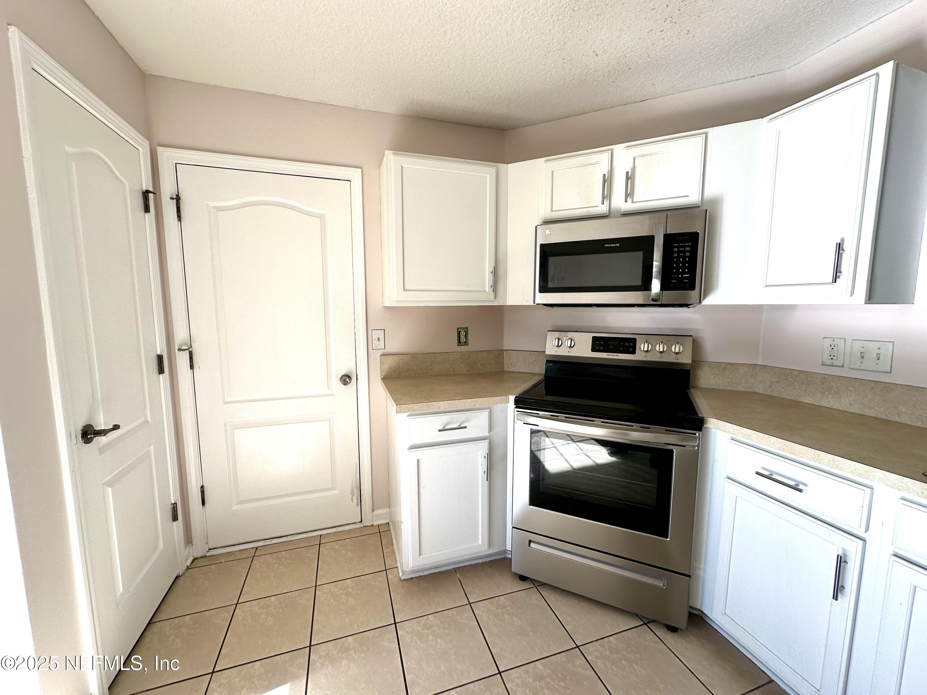 45575 Ingleham Circle Callahan, FL 32011 - Photo 6 of 24 a kitchen with white cabinets stainless steel appliances and a window