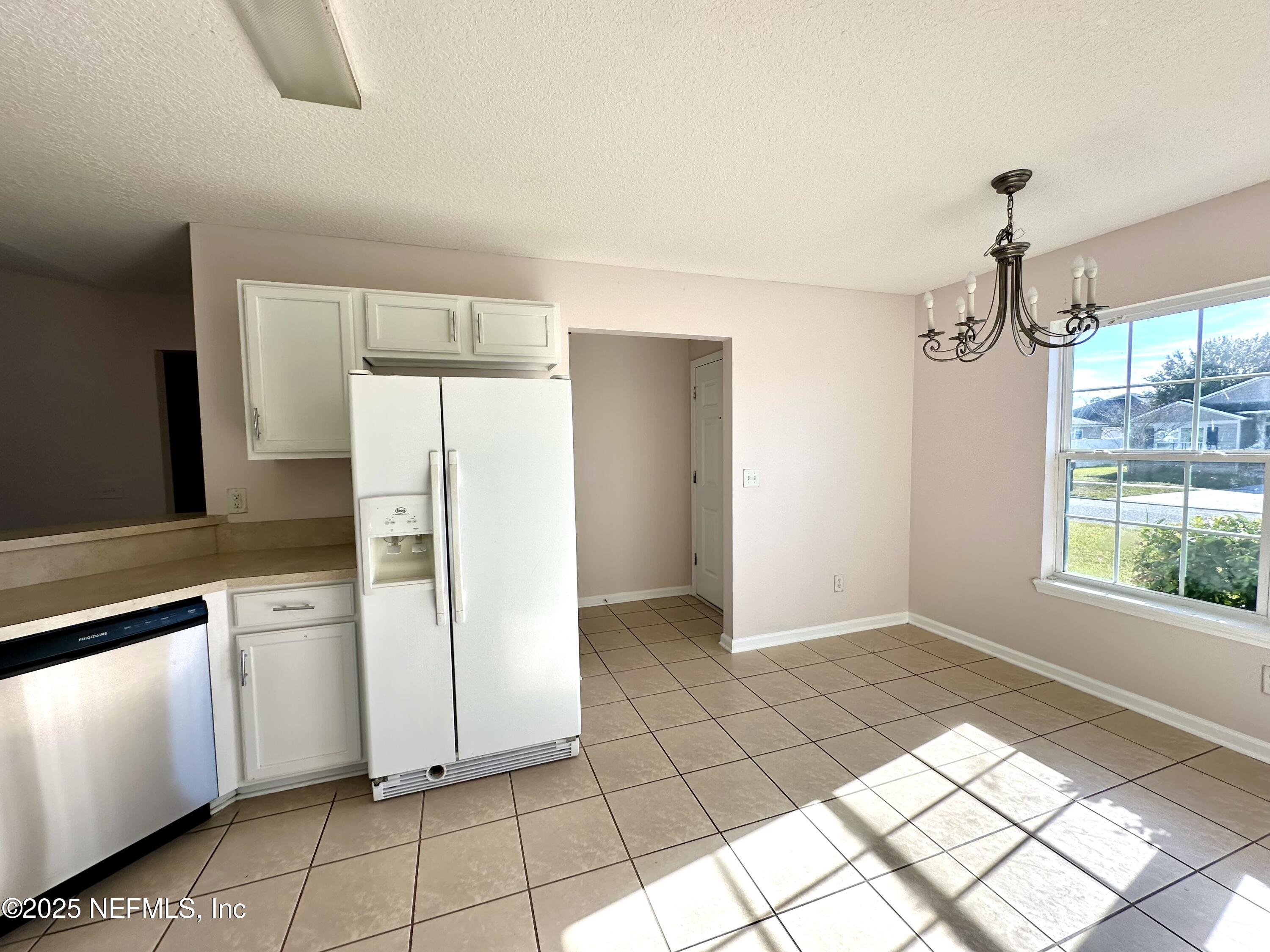 45575 Ingleham Circle Callahan, FL 32011 - Photo 7 of 24 a kitchen with a refrigerator a stove top oven and a window