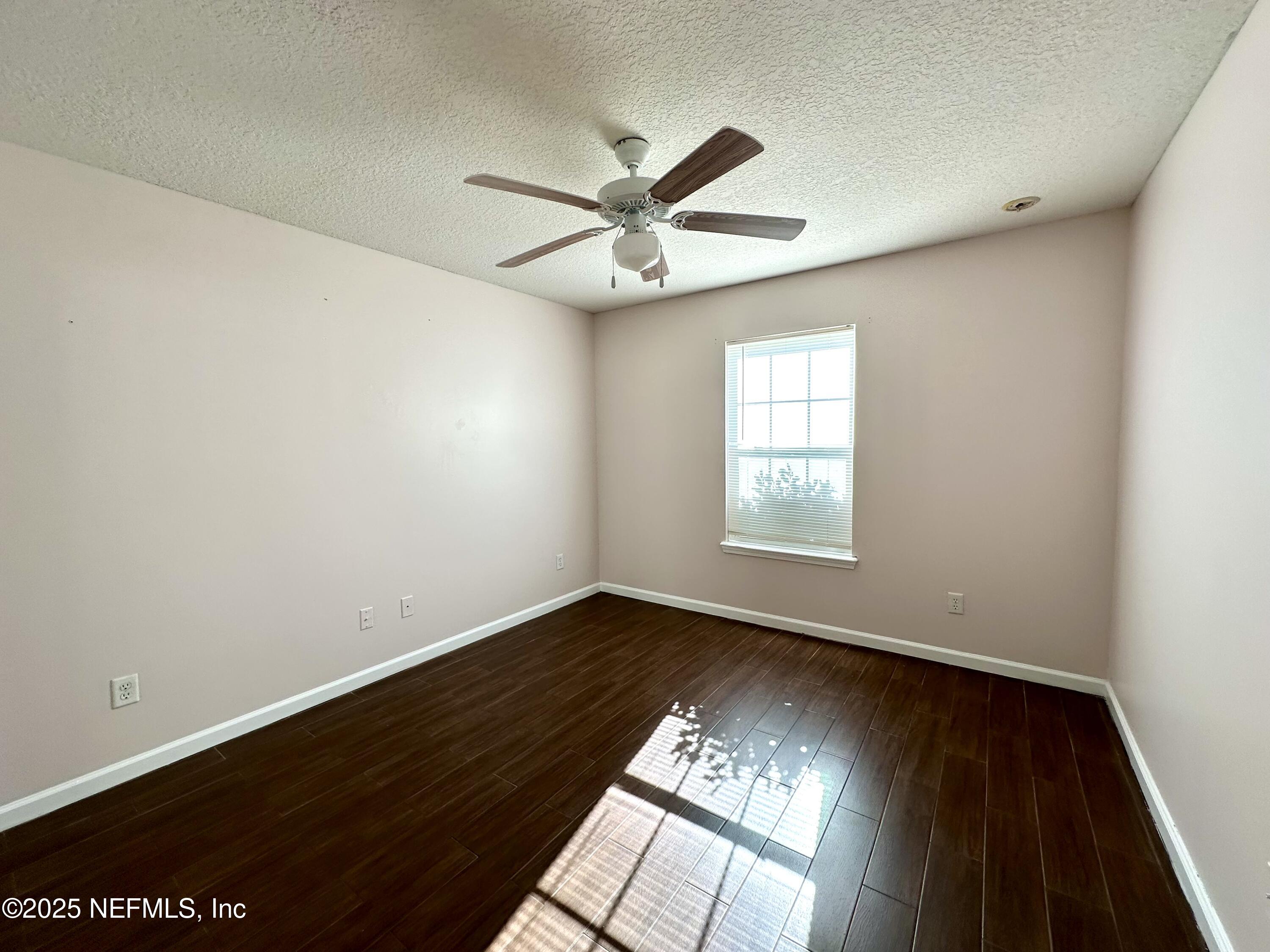 45575 Ingleham Circle Callahan, FL 32011 - Photo 9 of 24 an empty room with wooden floor fan and windows