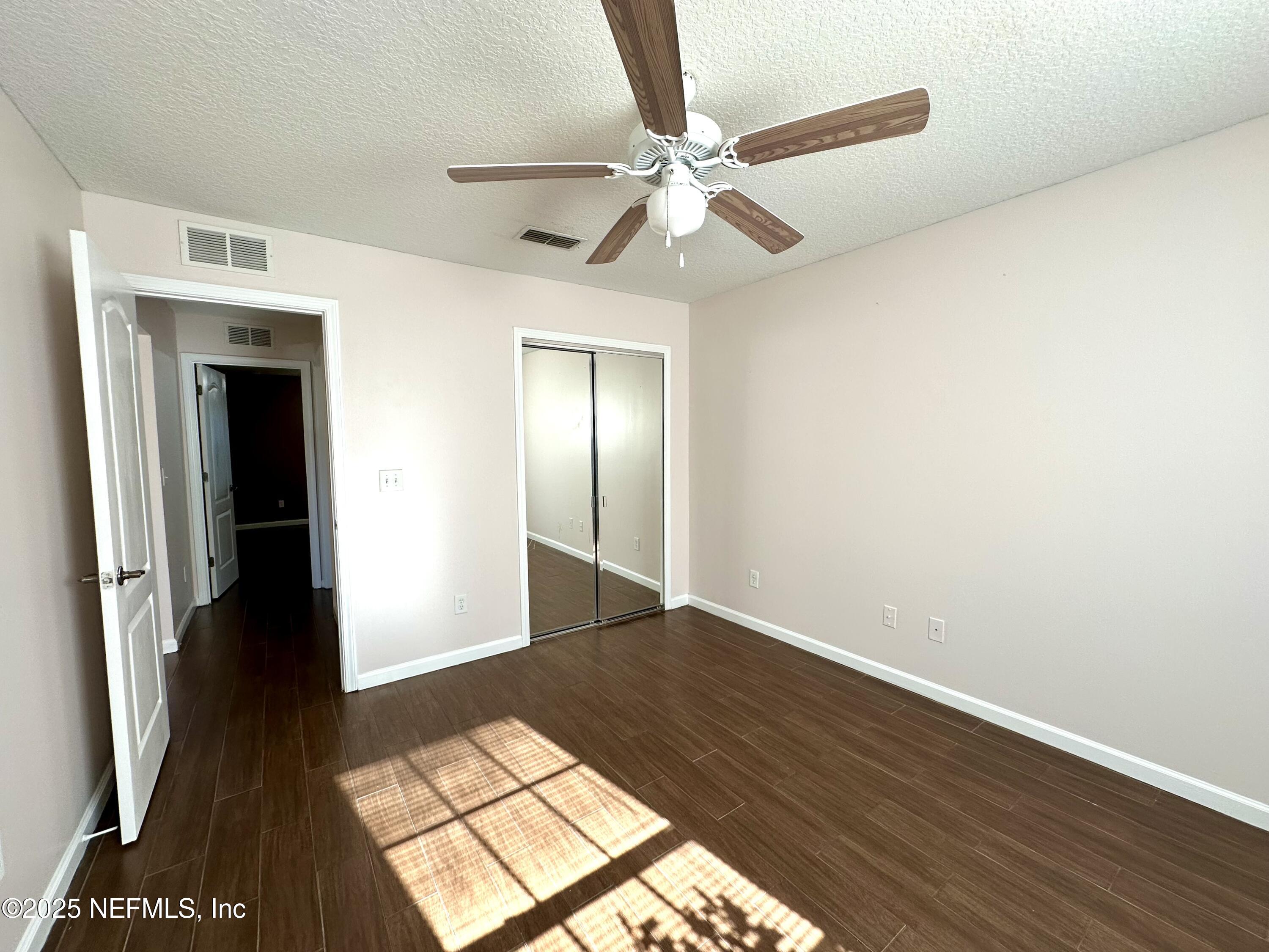 45575 Ingleham Circle Callahan, FL 32011 - Photo 10 of 24 a view of an empty room with wooden floor and a window
