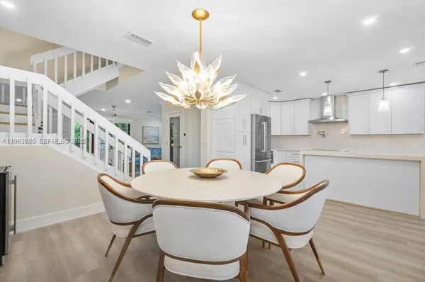 a kitchen with stainless steel appliances granite countertop a sink a stove and a wooden floor