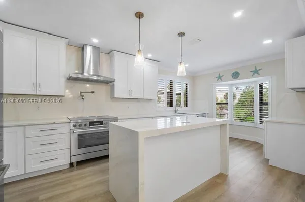 a dining room with wooden floor a chandelier a wooden table and chairs