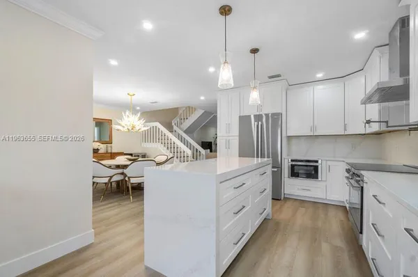 a kitchen with granite countertop kitchen island white cabinets and white appliances