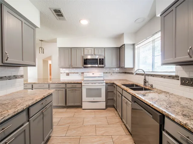 a kitchen with a sink stove top oven and microwave