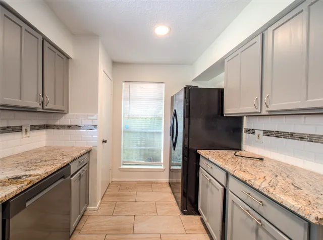 a kitchen with stainless steel appliances granite countertop a refrigerator and a sink