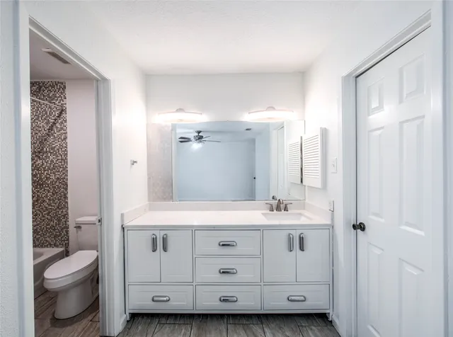 a bathroom with a double vanity sink toilet and shower