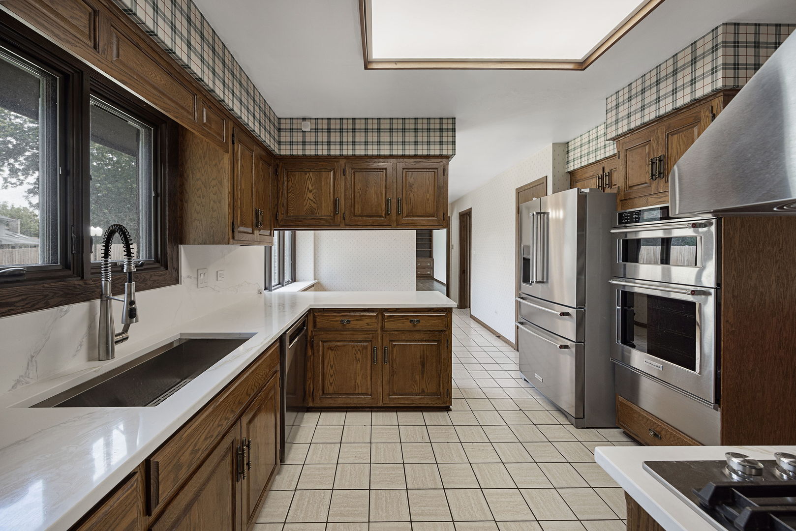 6723 Kingswood Road Willowbrook, IL 60527 - Photo 14 of 51 a kitchen with stainless steel appliances granite countertop a sink stove and refrigerator