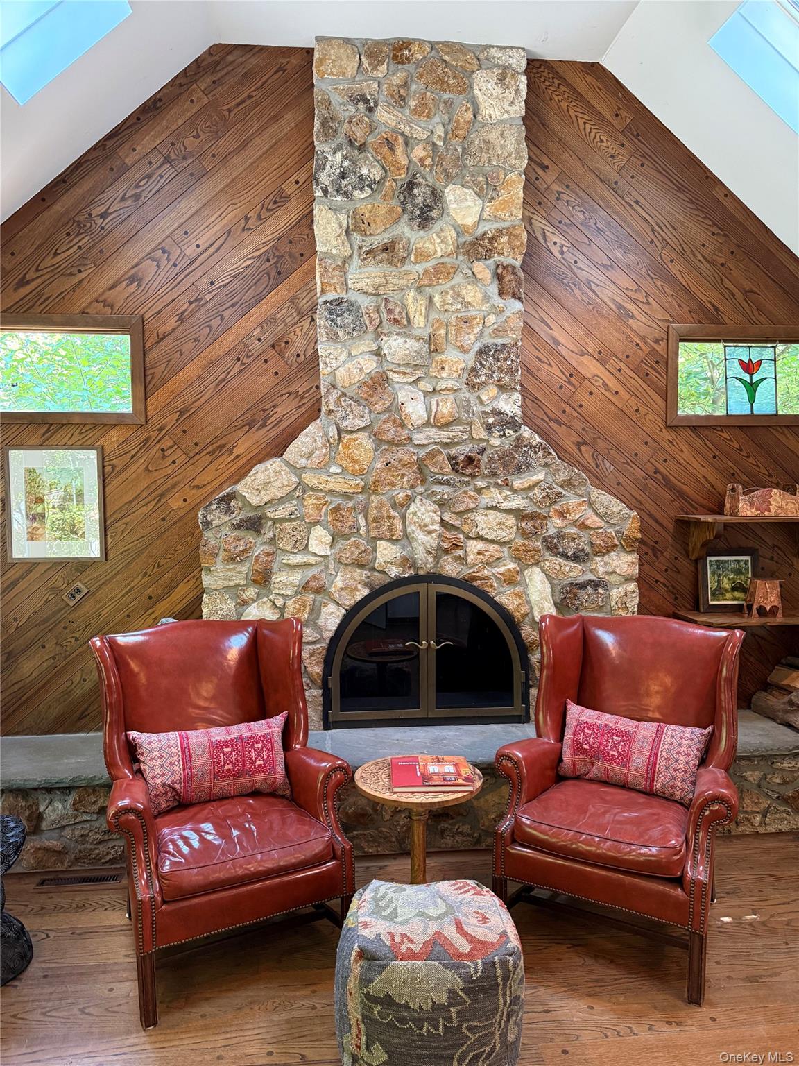 2 Terrace Road Suffern, NY 10901 - Photo 16 of 19 Floor-to-ceiling stone fireplace with an arched firebox, wood-finish flooring, and sloped wood-paneled walls