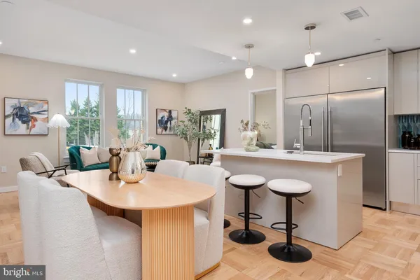 a kitchen with stainless steel appliances kitchen island granite countertop a sink and a refrigerator