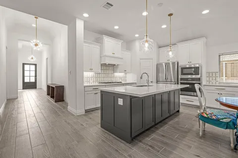 a large kitchen with kitchen island a sink counter space appliances and a large window