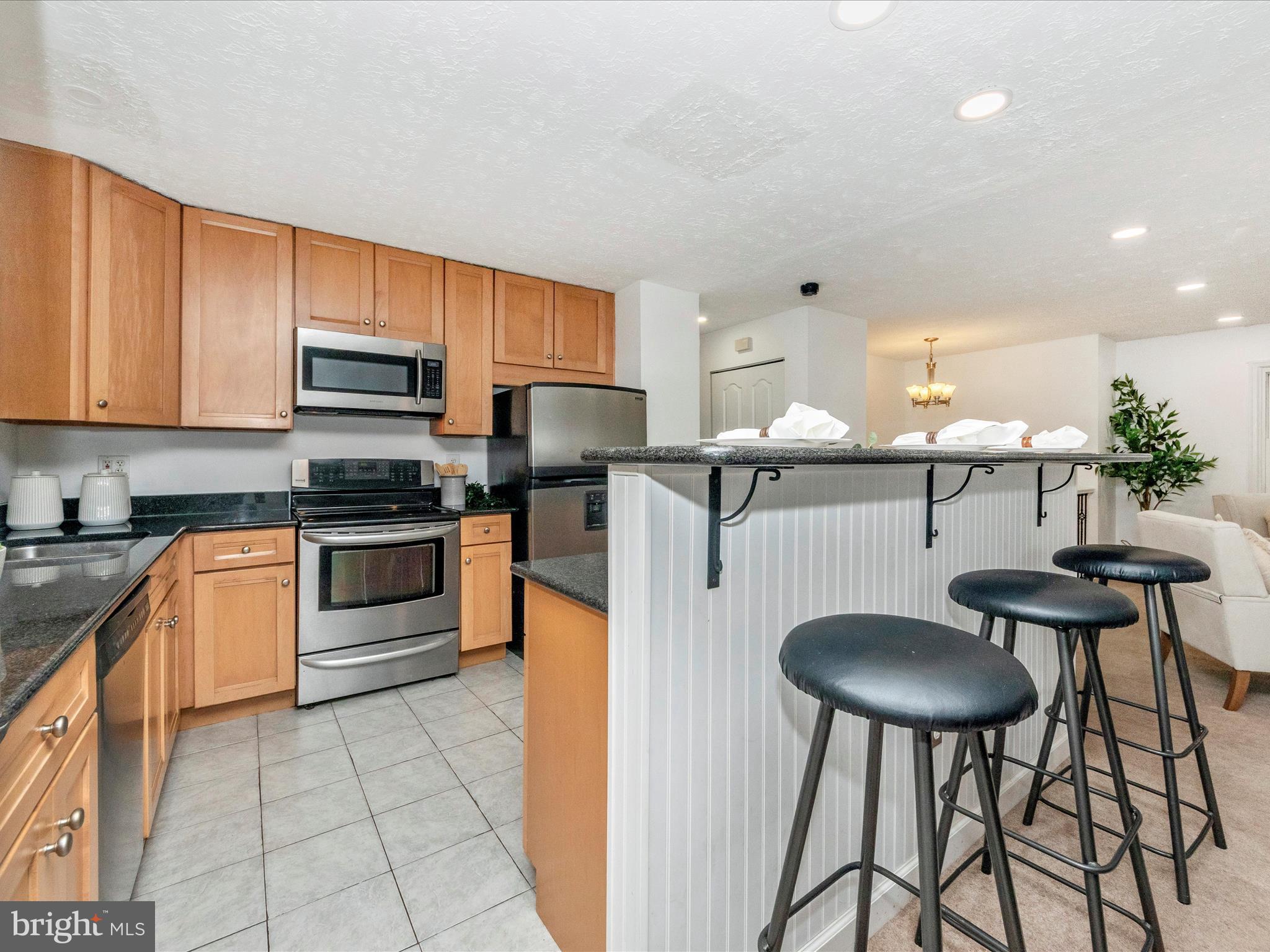 1825 Montreal Road Severn, MD 21144 - Photo 14 of 51 a kitchen with stainless steel appliances a stove a sink cabinets and a dining table