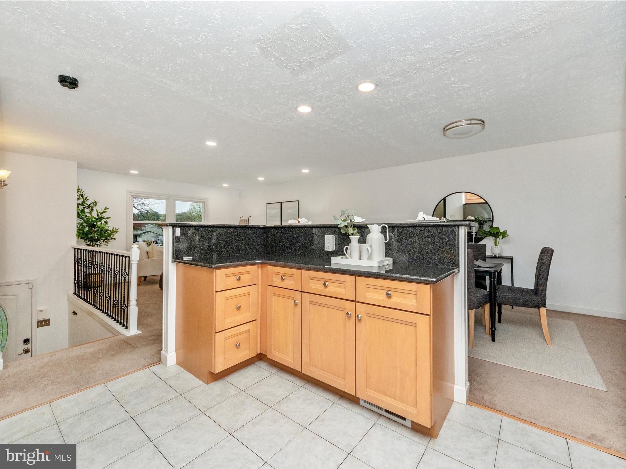 1825 Montreal Road Severn, MD 21144 - Photo 18 of 51 a kitchen with granite countertop white cabinets and chairs