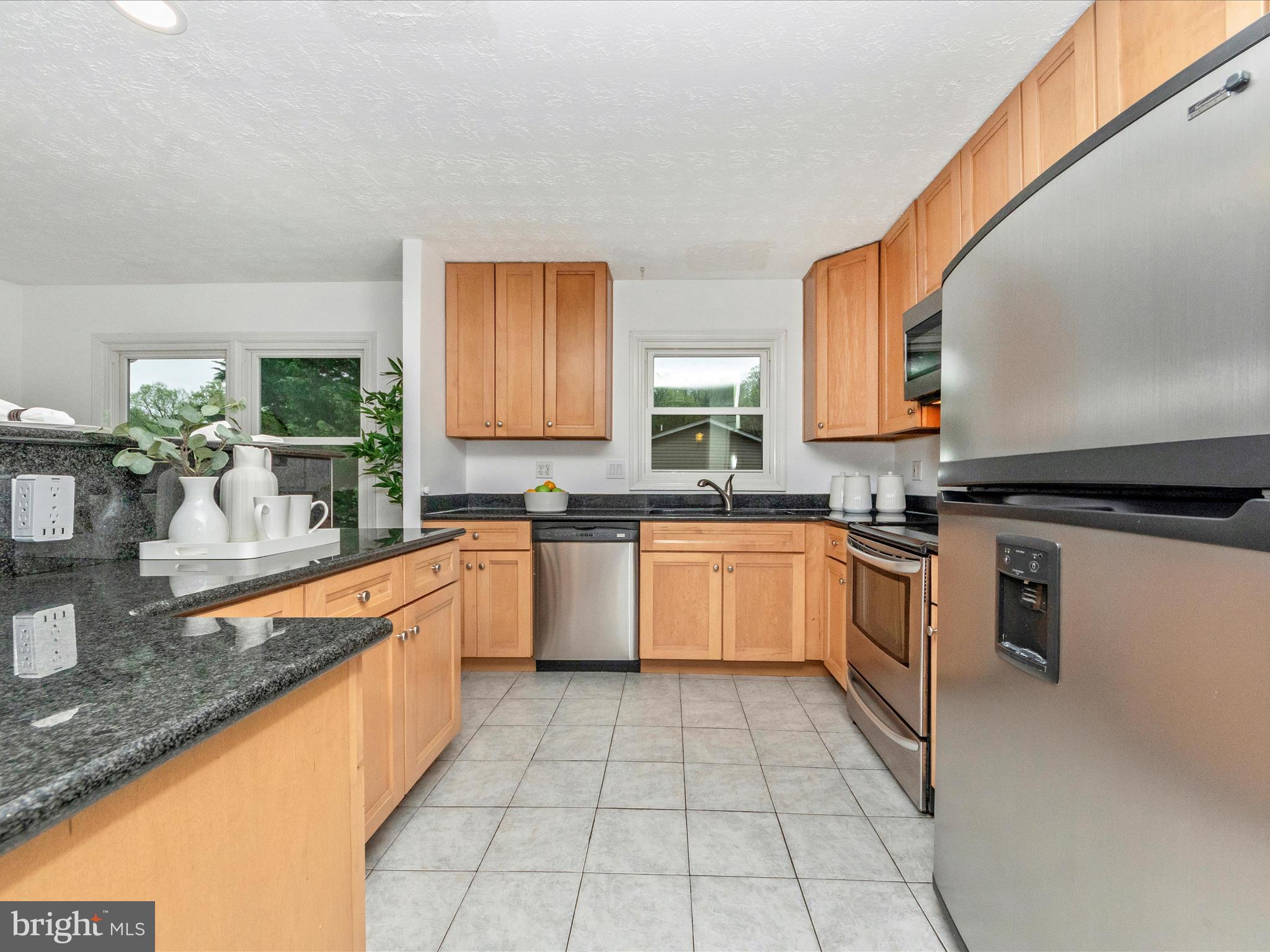 1825 Montreal Road Severn, MD 21144 - Photo 19 of 51 a large kitchen with granite countertop a stove a sink dishwasher and a microwave oven on granite countertops