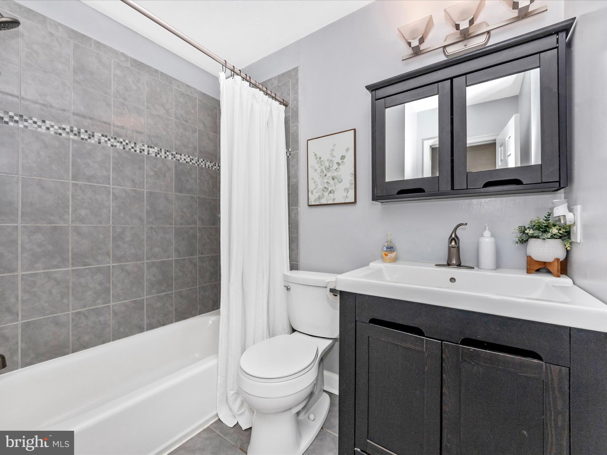 1825 Montreal Road Severn, MD 21144 - Photo 32 of 51 a bathroom with a bathtub shower sink vanity and toilet