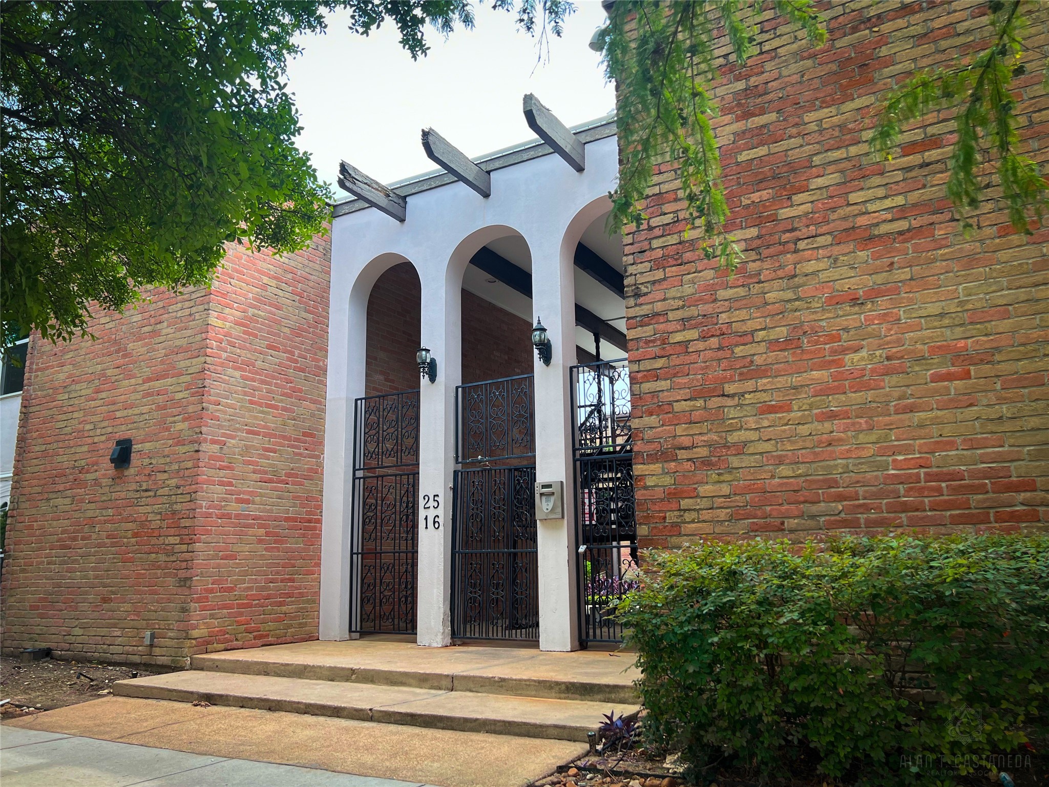 2516 Commonwealth Street, Unit 102 Houston, TX 77006 - Photo 2 of 28 a front view of a house with a garden