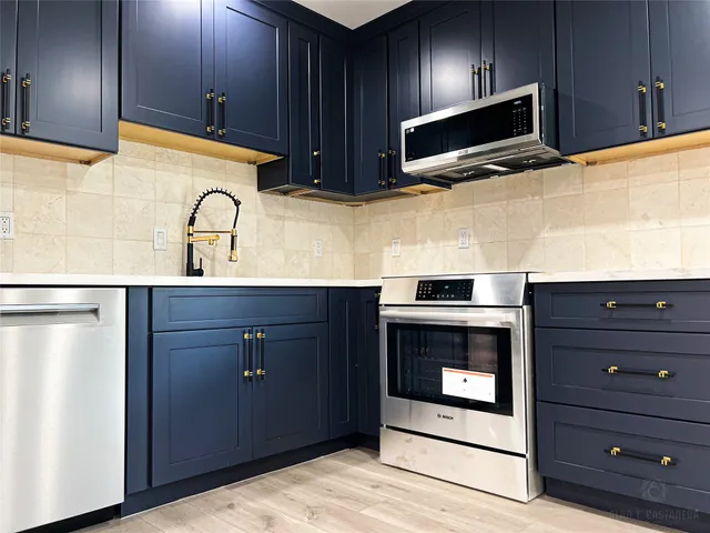 a kitchen with stainless steel appliances wooden cabinets and a sink