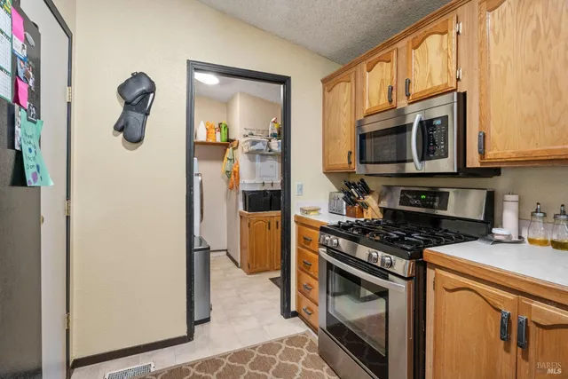 a kitchen with stainless steel appliances granite countertop a refrigerator a stove a sink and dishwasher