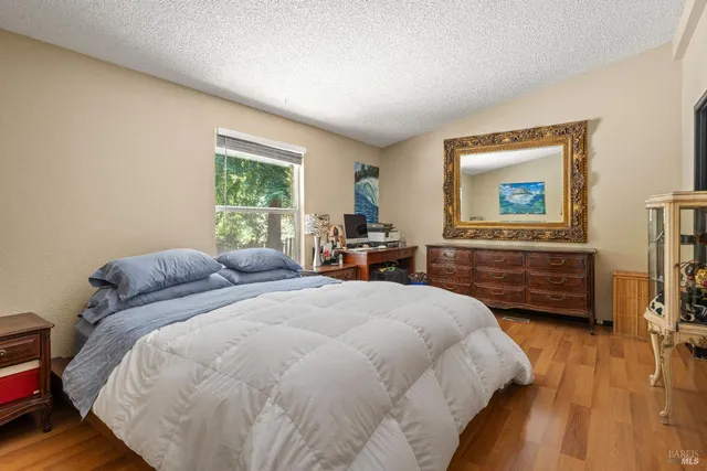 a bedroom with a bed and wooden floor