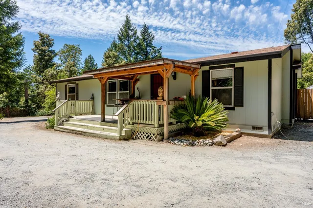 a view of a house with a patio and a yard
