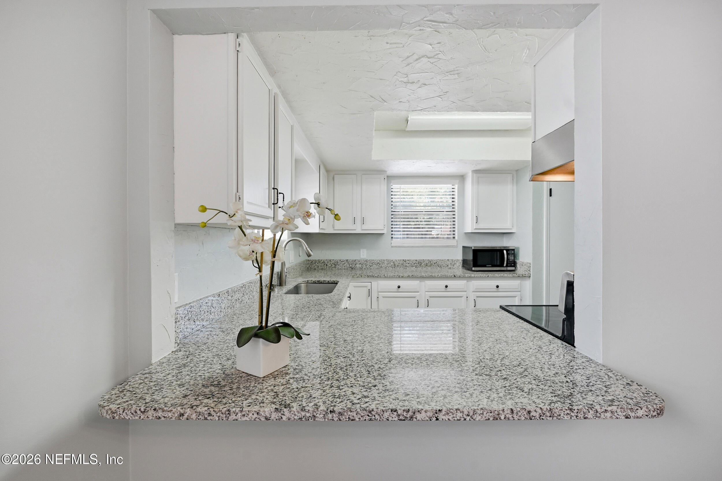 144 Poinsettia Street Atlantic Beach, FL 32233 - Photo 11 of 42 a kitchen with kitchen island granite countertop a counter top space and stainless steel appliances