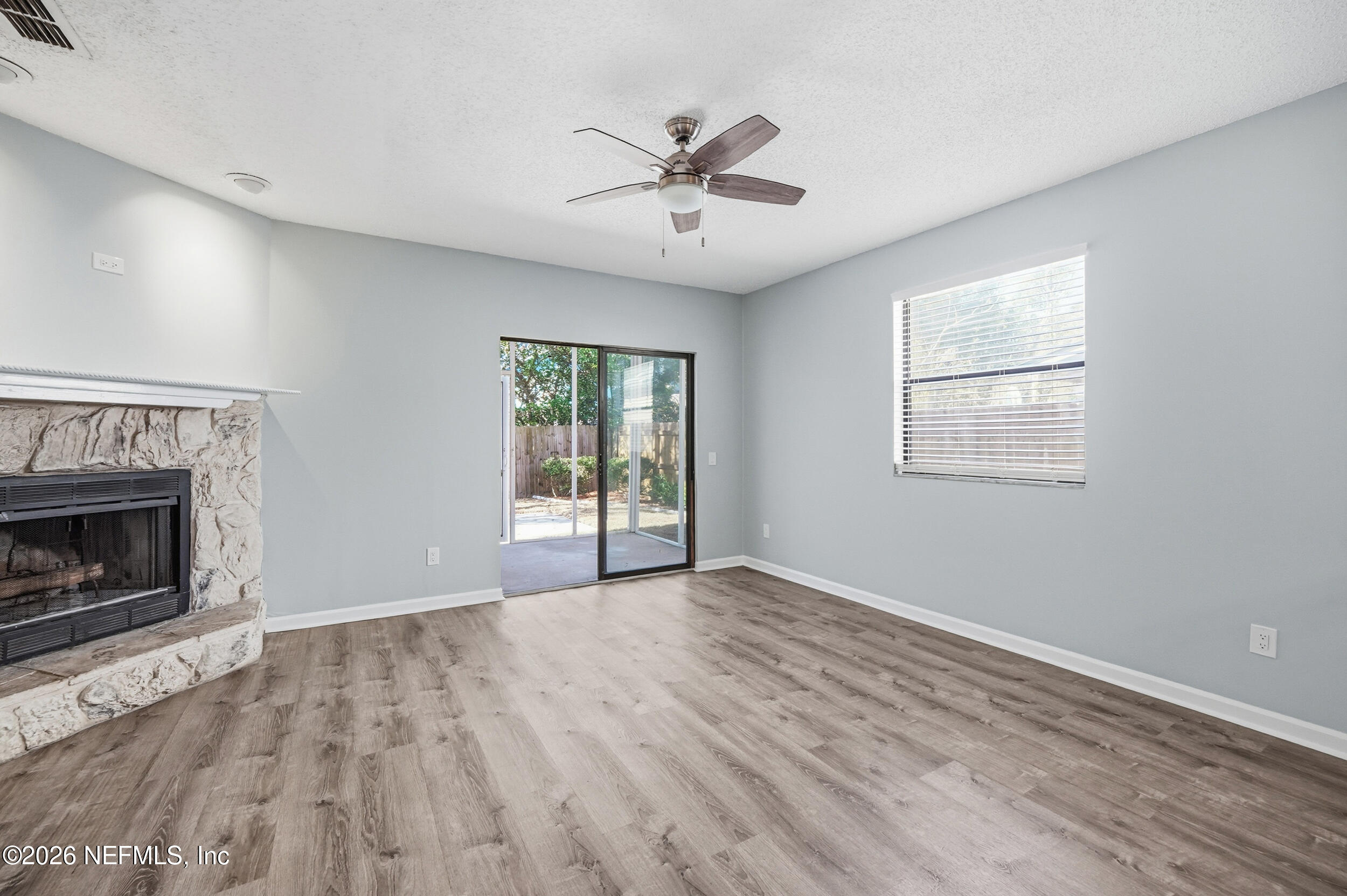 144 Poinsettia Street Atlantic Beach, FL 32233 - Photo 15 of 42 an empty room with wooden floor fireplace and windows