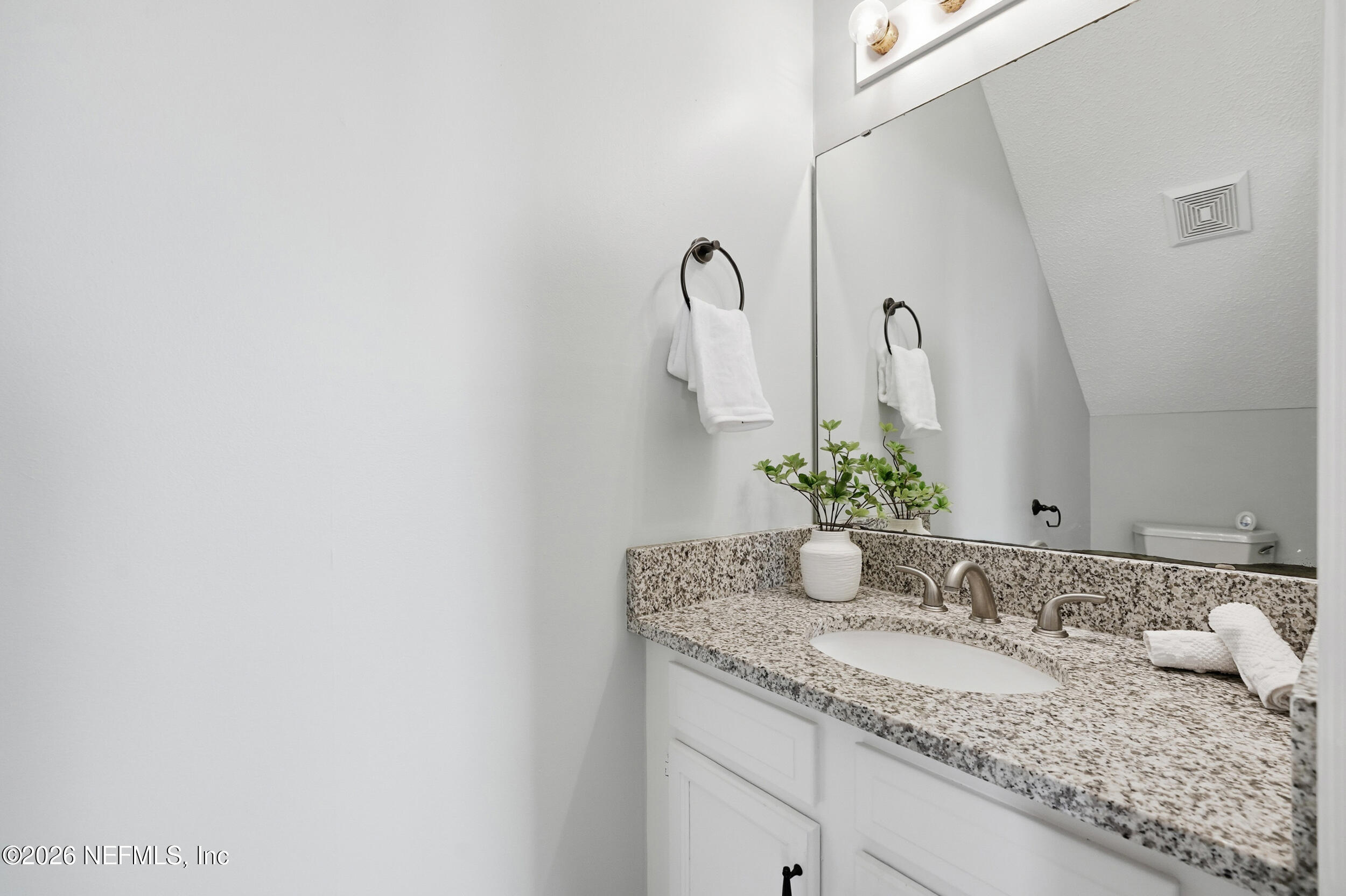 144 Poinsettia Street Atlantic Beach, FL 32233 - Photo 18 of 42 a bathroom with a granite countertop sink and a mirror
