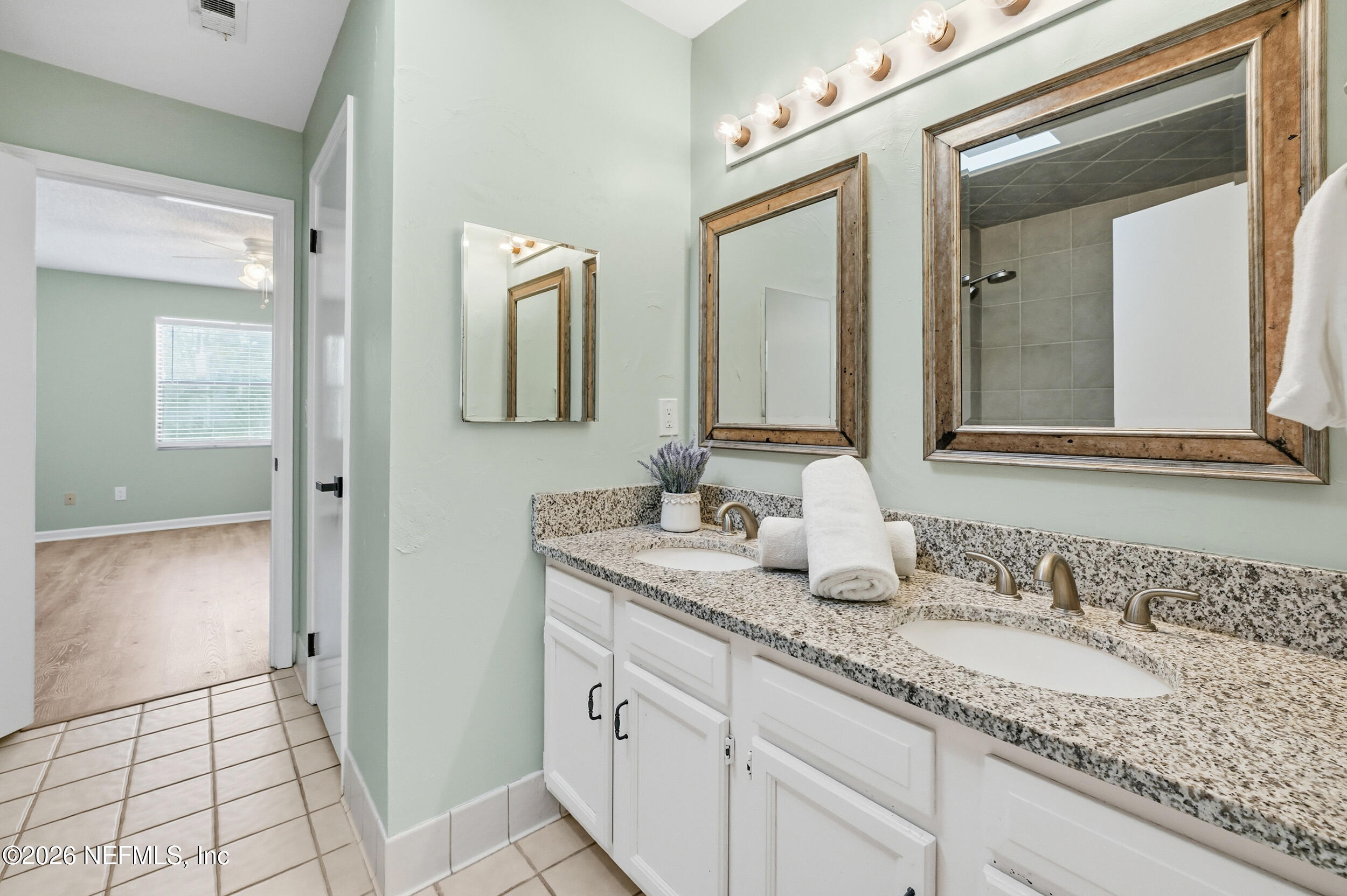 144 Poinsettia Street Atlantic Beach, FL 32233 - Photo 28 of 42 a bathroom with a granite countertop sink and a mirror