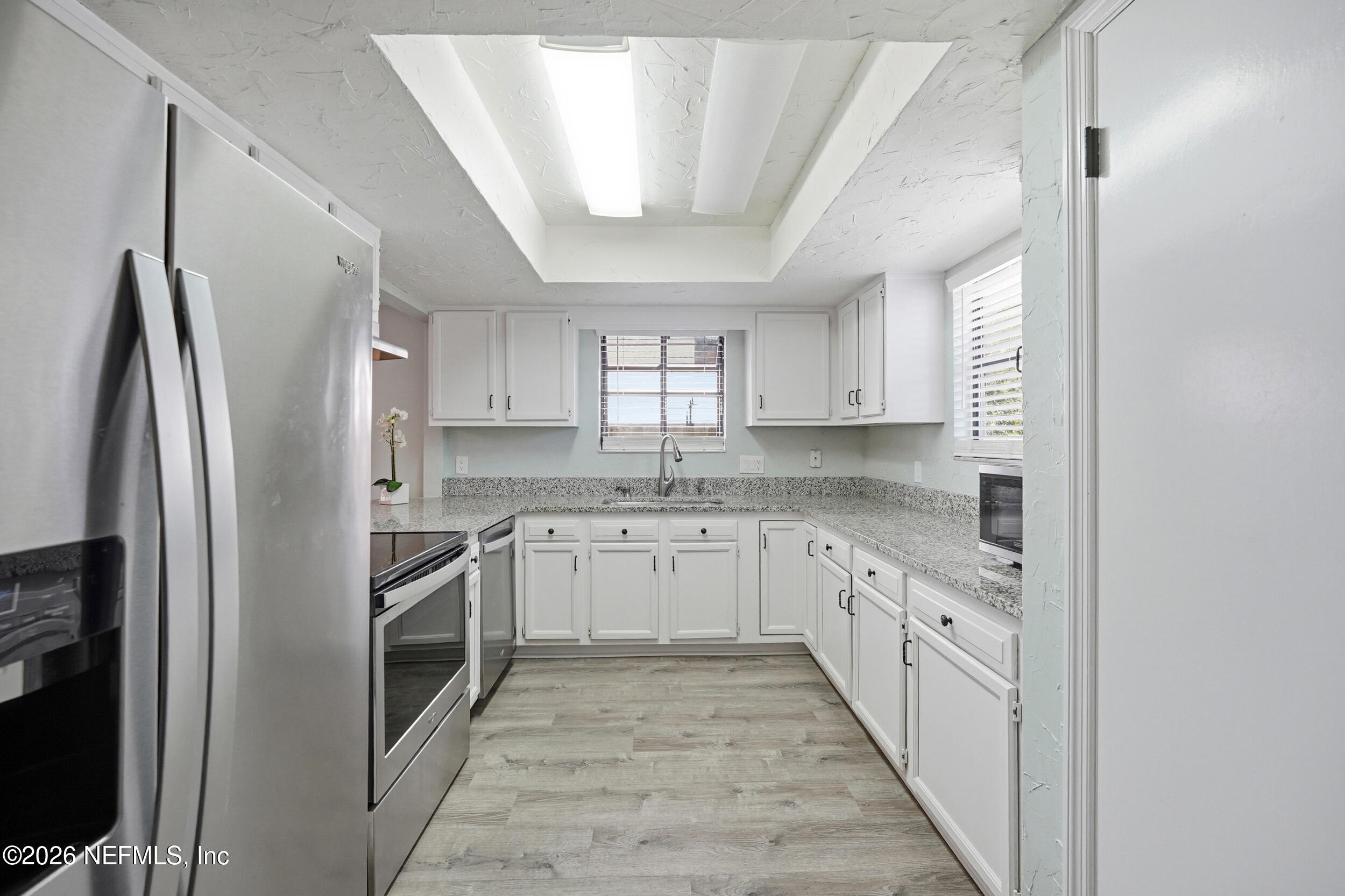 144 Poinsettia Street Atlantic Beach, FL 32233 - Photo 6 of 42 a kitchen with granite countertop a sink stainless steel appliances and cabinets