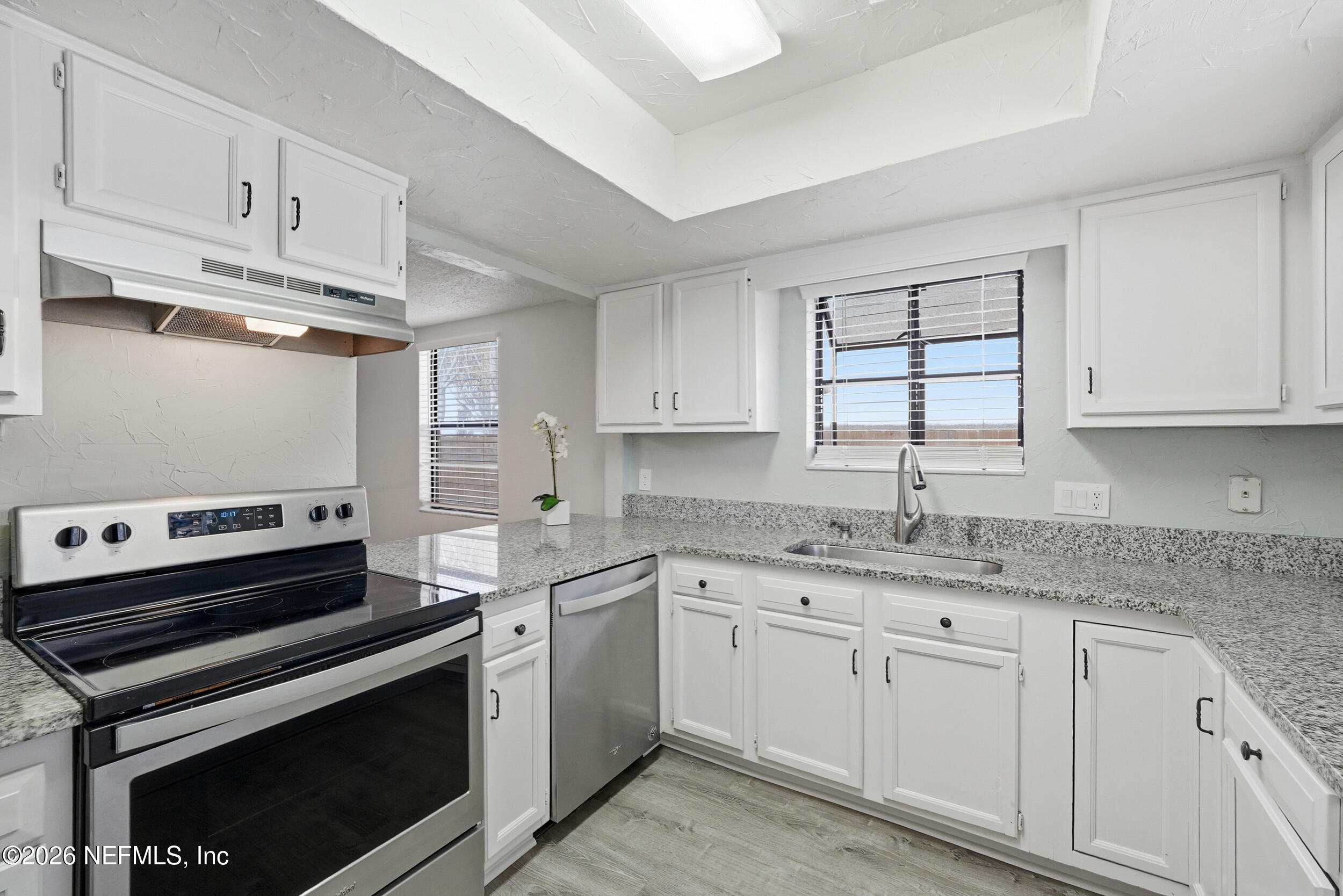 144 Poinsettia Street Atlantic Beach, FL 32233 - Photo 7 of 42 a kitchen with cabinets appliances a sink and a window