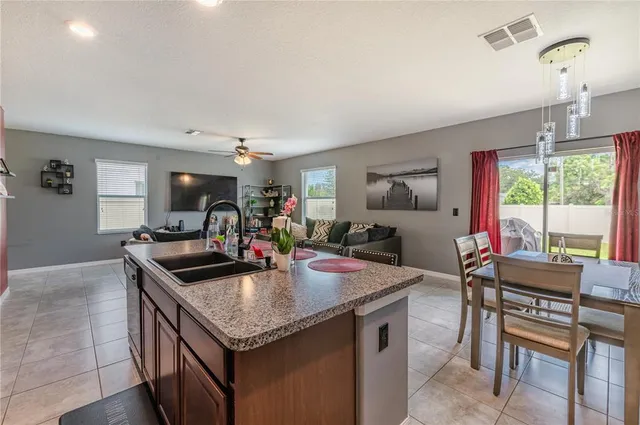 a kitchen island with granite countertop a table and chairs in it