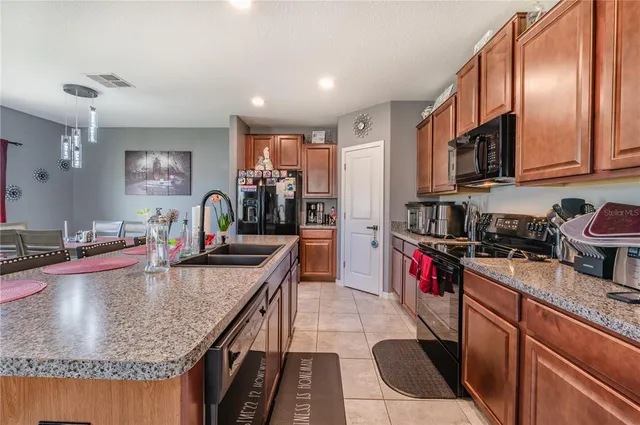 a kitchen with kitchen island granite countertop a stove a sink and a refrigerator