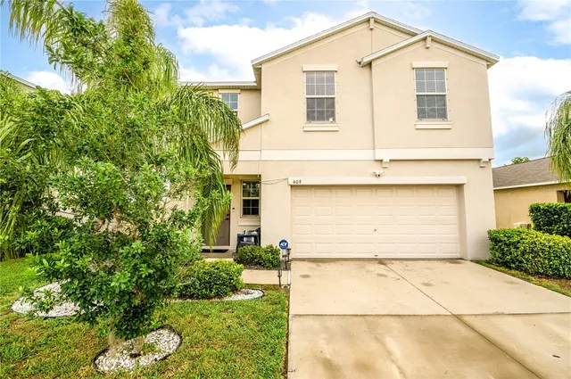 a front view of a house with a yard and garage
