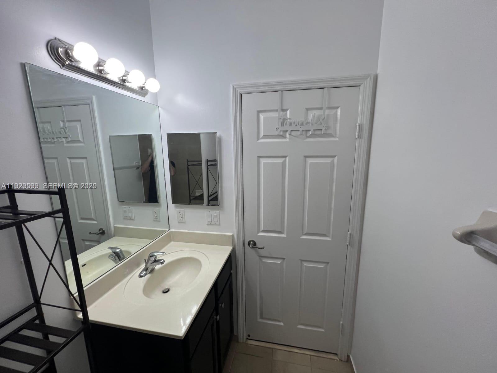 3399 West 90th Terrace Hialeah, FL 33018 - Photo 15 of 59 a bathroom with a sink vanity and mirror