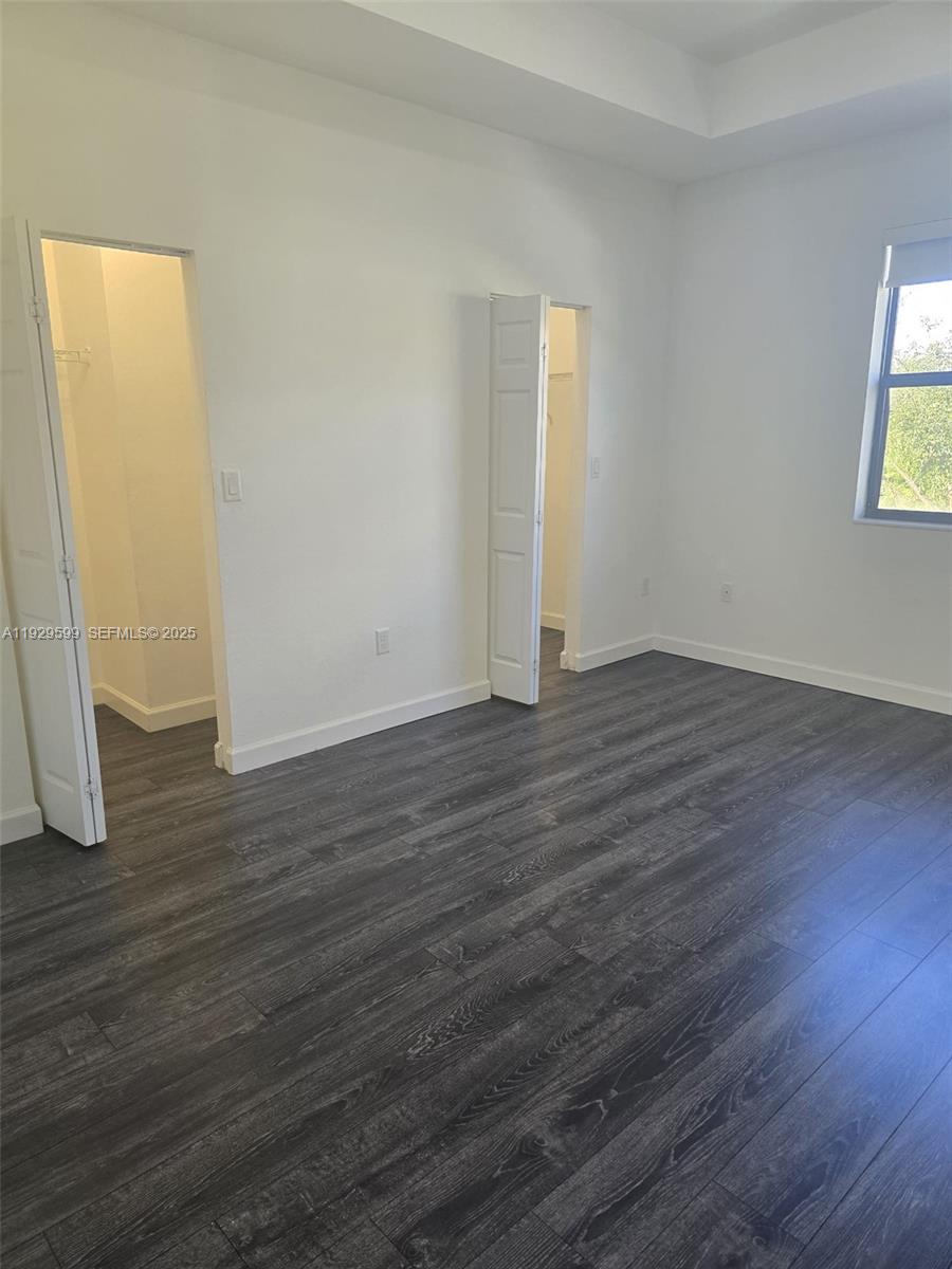 3399 West 90th Terrace Hialeah, FL 33018 - Photo 29 of 59 an empty room with wooden floor and windows