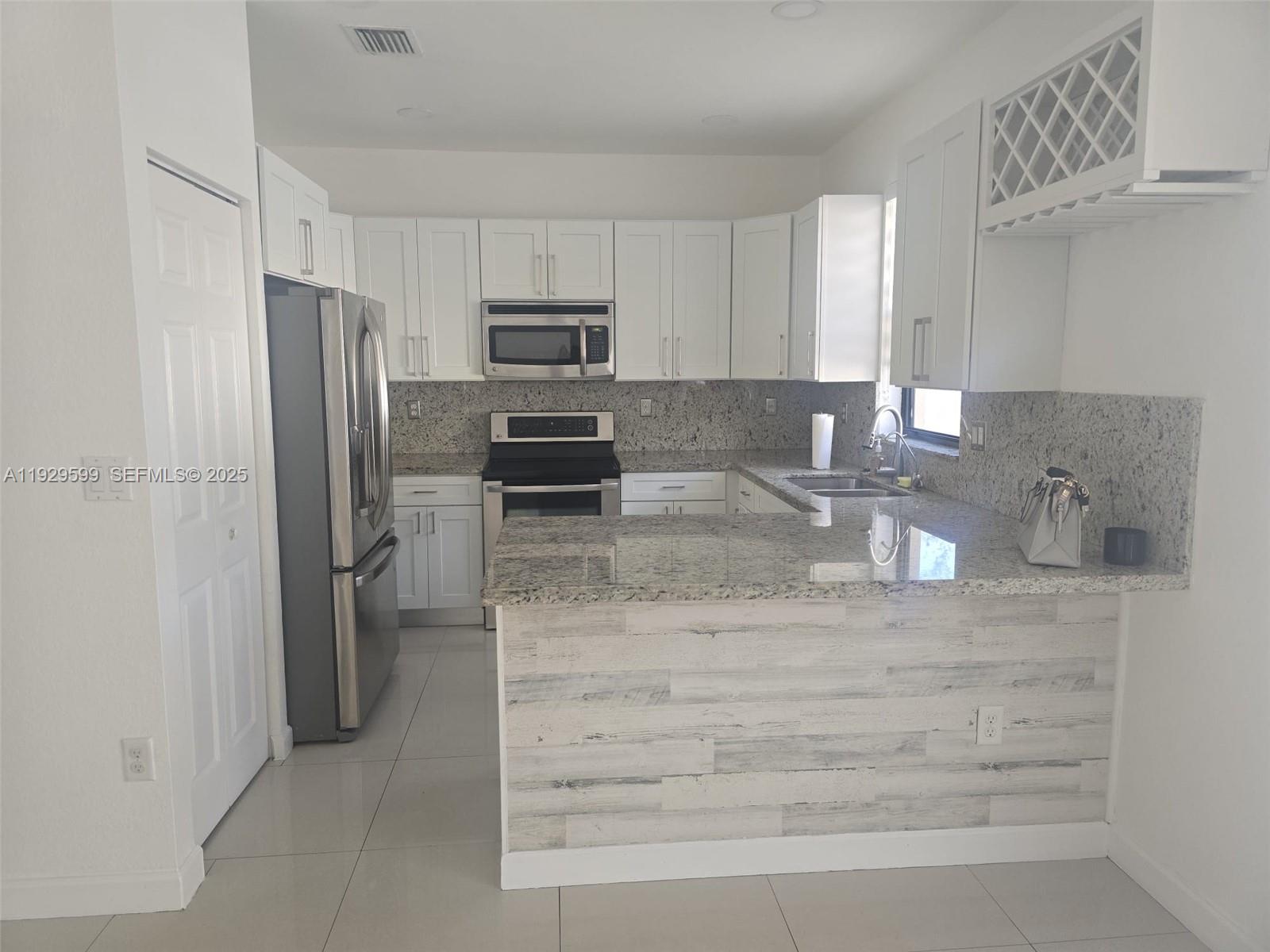 3399 West 90th Terrace Hialeah, FL 33018 - Photo 3 of 59 a kitchen with stainless steel appliances granite countertop a refrigerator and a stove