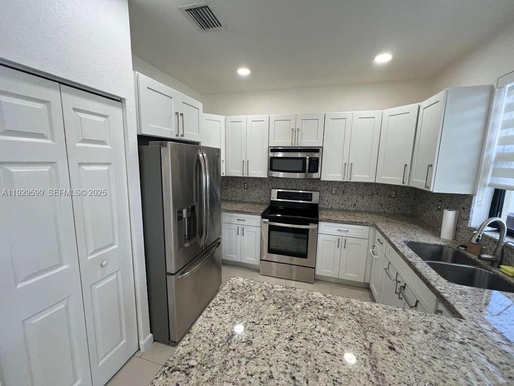 3399 West 90th Terrace Hialeah, FL 33018 - Photo 5 of 59 a kitchen with a refrigerator stove and sink