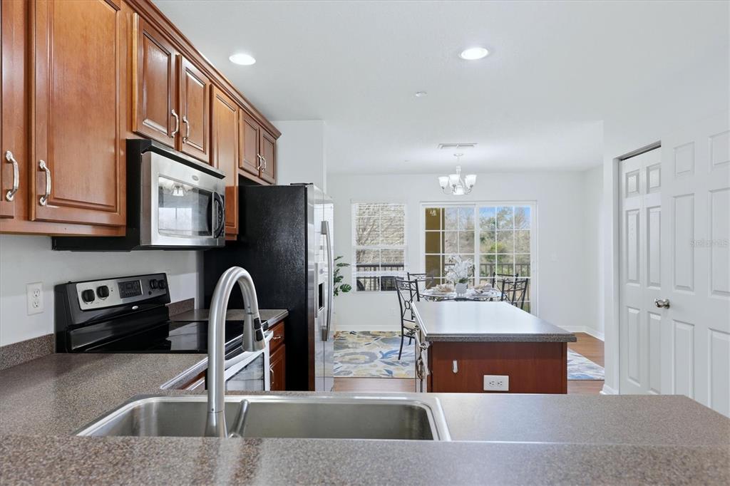 9038 White Sage Loop Lakewood Ranch, FL 34202 - Photo 11 of 52 a kitchen with stainless steel appliances granite countertop a sink and a refrigerator
